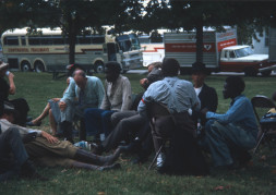 Cast and crew members, including Dana Elcar (Kirky), on ground, Don Dubbins (Harley Davis) with elbow up, and malcolm attebury (Silas Newhall0 in black hat sitting taking a break on a lawn in front of production buses.