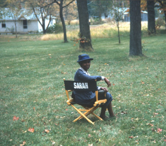 Actress Estelle Evans (Sarah Winger) seated in her actor‚Äôs chair.