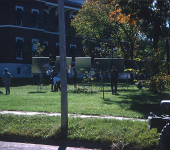 Production crew prepare reflective lighting panels outside of the courthouse from the trial scene for filming.