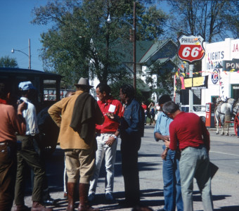 Director Gordon Parks (wearing blue denim jacket) talking to crew and Dana Elcar (Kirky) in tan suit jacket, back to camera in downtown Ft. Scott, Kansas.