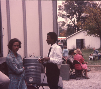 Actor Kyle Johnson (Newt Winger) wearing black tie and suspenders, on the set. The photograph was likely taken around the filming of the Sarah Winger‚Äôs funeral scene.