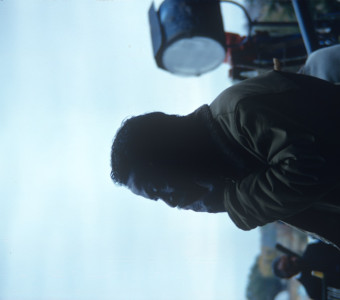 Profile view of Director Gordon Parks in front of production equipment.