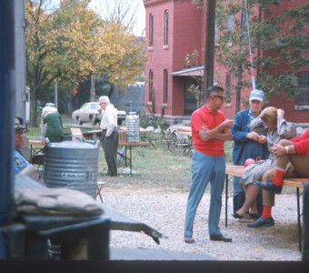 Actors and crew outside of courthouse building with drink coolers.