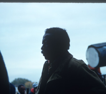 Director Gordon Parks on the set in front of produciton equipment.