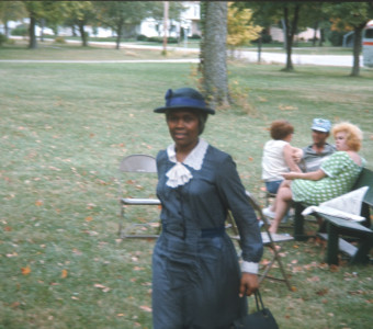 Actress Estelle Evans (Sarah Winger) stands in front of other actors and crew. The photograph was likely taken around the filming of the trial scene.