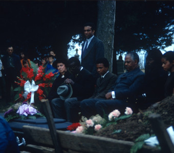 Actors Hope Summers (Mrs. Kiner), Joel Flullen (Uncle Rob), Phillip Roye (Pete Winger), Felix Nelson (Jack Winger), S. Pearl Sharpe (Prissy), and other actors, crew, and observers, during the filming of Sarah Winger‚Äôs funeral scene.