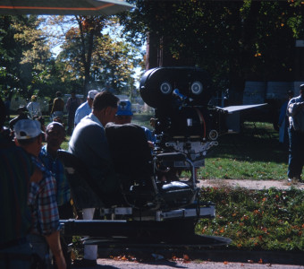 Crew filming a scene with camera outside of the courthouse used in the trial scene. Actor Kyle Johnson (Newt Winger) stands in the background (left, mustard colored sweater).