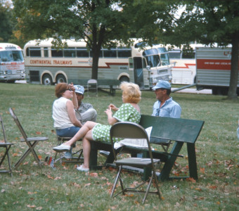 Actors and crew seated in front of production vehicles wearing Learning Tree hats.