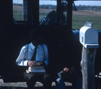 Actor Kyle Johnson (Newt Winger) and another actor (obscured) sitting on black antique car.