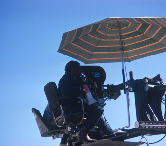 Director Gordon Parks with crew members filming from above while holding a megaphone.