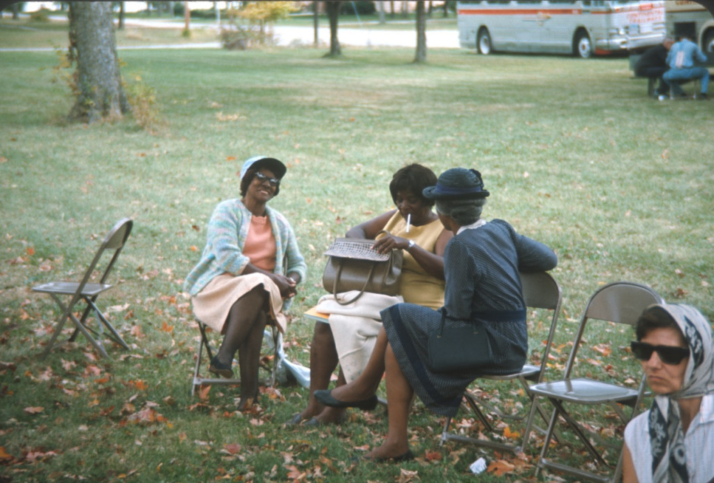 Three African American actresses, including Estelle Evans (Sarah Winger), in dark dress, seated together.