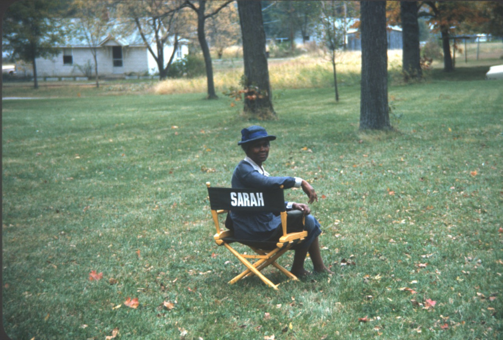 Actress Estelle Evans (Sarah Winger) seated in her actor‚Äôs chair.