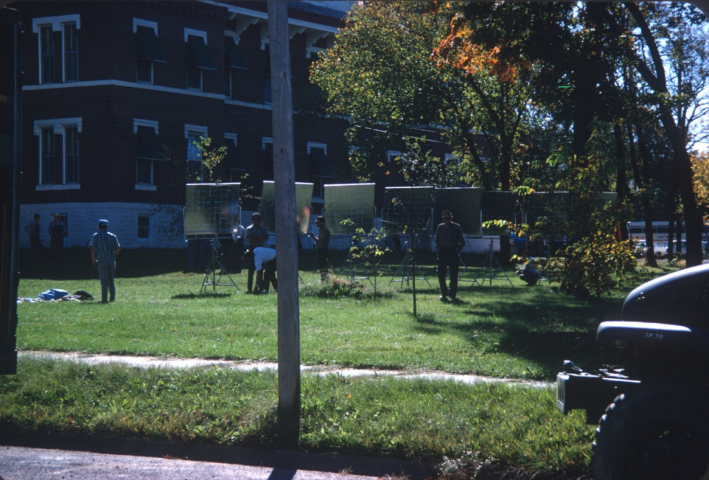 Production crew prepare reflective lighting panels outside of the courthouse from the trial scene for filming.