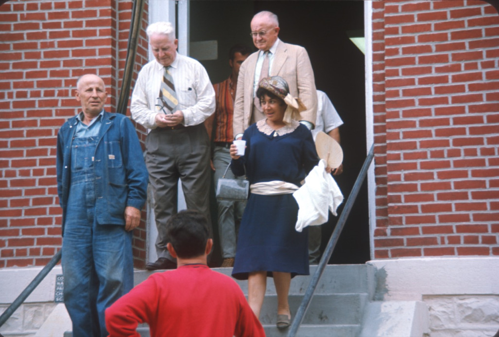 Actors exiting courthouse from trial scene.