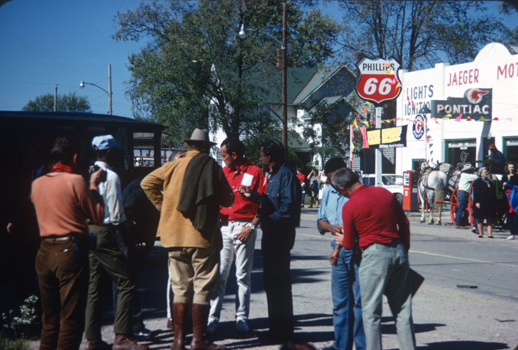 Director Gordon Parks (wearing blue denim jacket) talking to crew and Dana Elcar (Kirky) in tan suit jacket, back to camera in downtown Ft. Scott, Kansas.