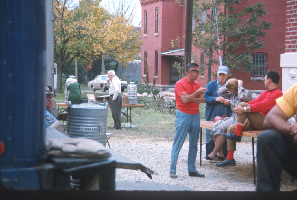 Actors and crew outside of courthouse building with drink coolers.