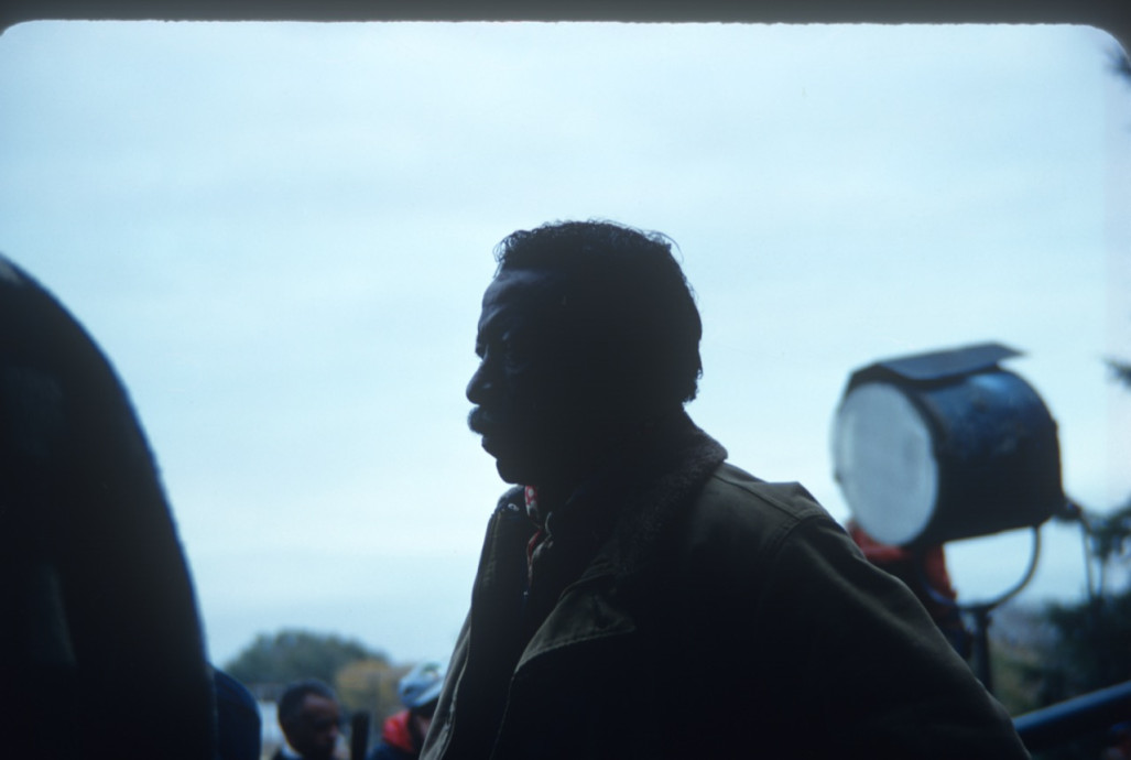 Director Gordon Parks on the set in front of produciton equipment.