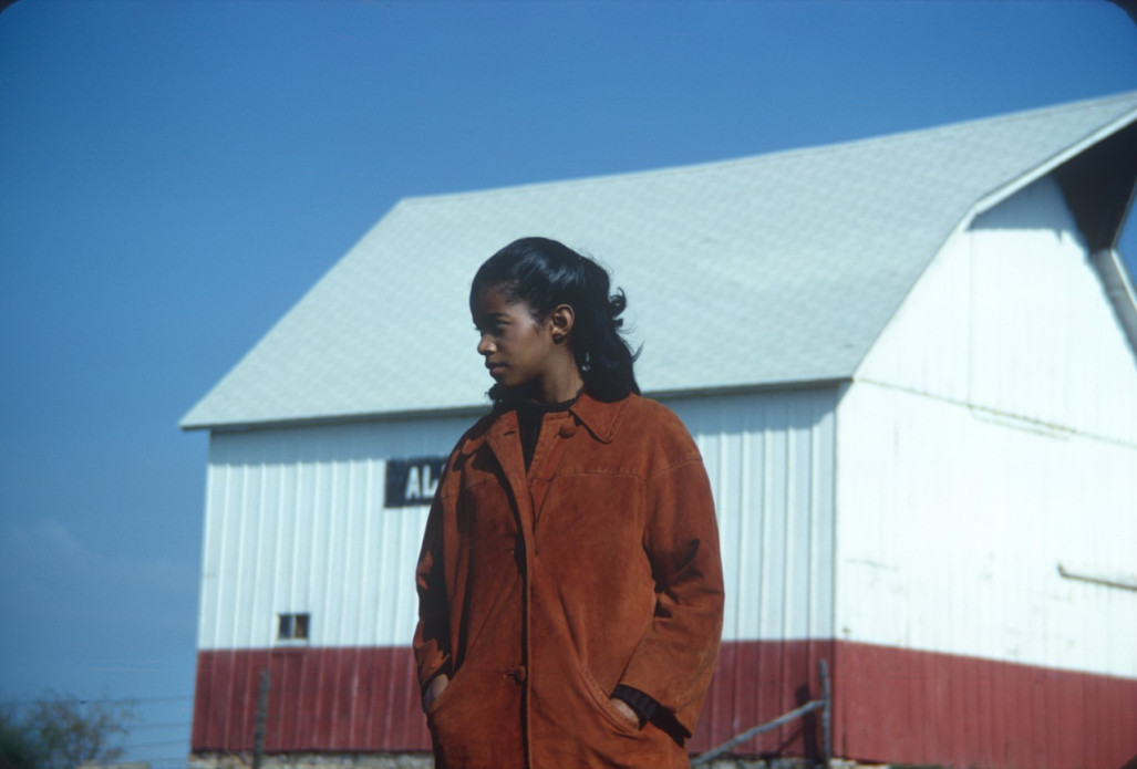 Actress S. Pearl Sharpe (Prissy) in front of a red and white barn.