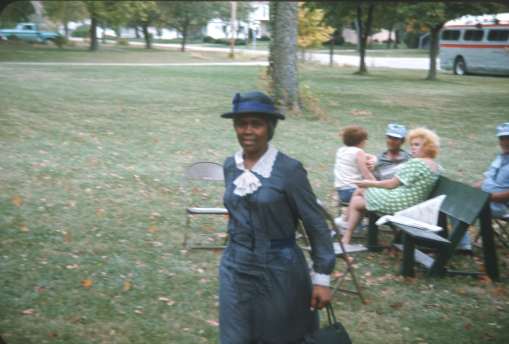 Actress Estelle Evans (Sarah Winger) stands in front of other actors and crew. The photograph was likely taken around the filming of the trial scene.