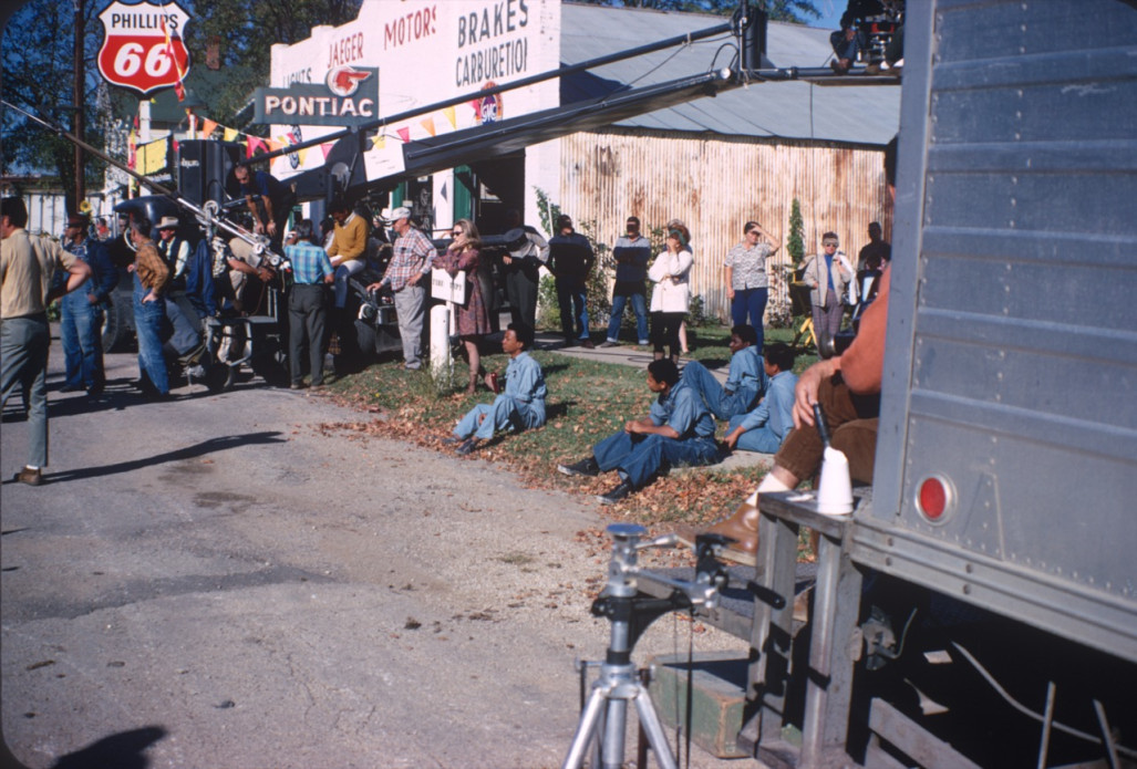 Cast and crew, including Kyle Johnson (Newt Winger), Stephen Perry (Jappy), Carter Vinnegar (Seansy), and Bobby Goss (Skunk) in blue jumpsuits and seated, left, filming a scene in downtown Fort Scott, Kansas.