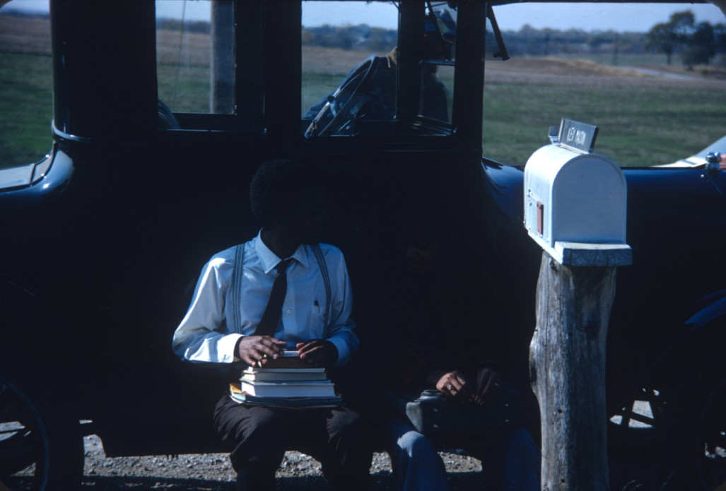 Actor Kyle Johnson (Newt Winger) and another actor (obscured) sitting on black antique car.